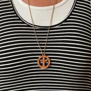 A person wearing a necklace with a cross on it.