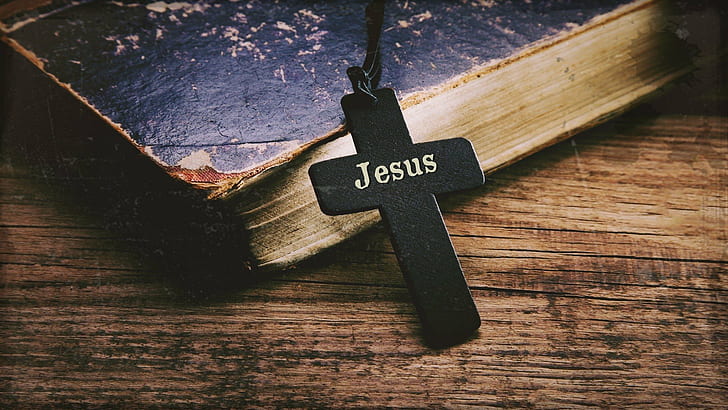Jesus text on cross wood placed on the book